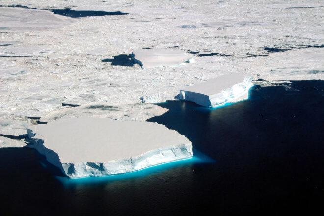 sea ice in the Antarctic, white patches of ice against deep blue water