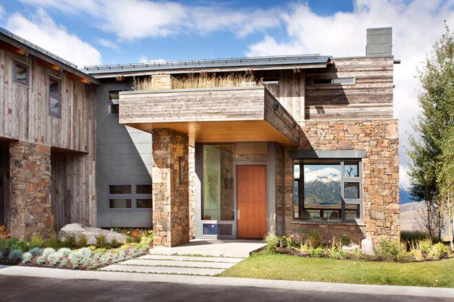 orange front door covered by a green roof