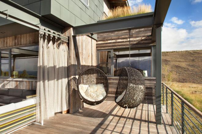 two hanging oval chairs on an open outdoor patio