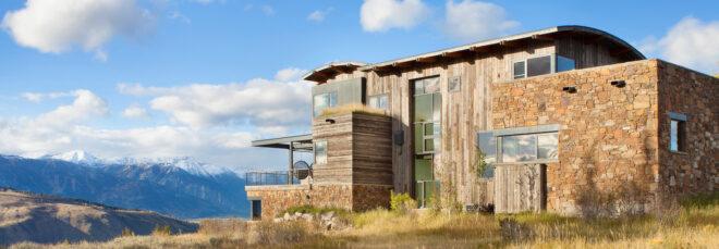 wood and stone home with curved roof