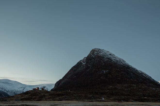 two small cabins next to a mountain