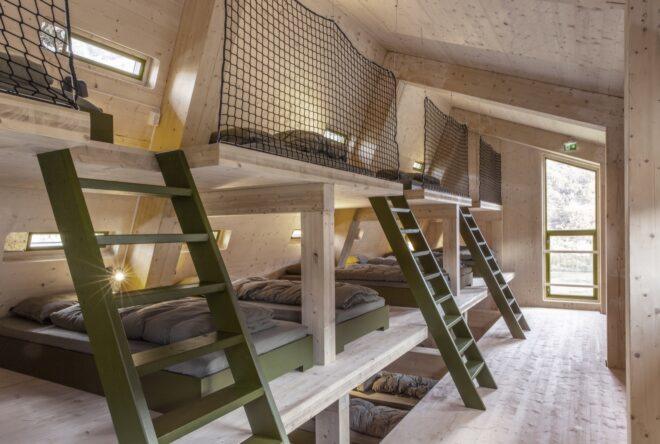 timber-framed bunk beds with green ladders