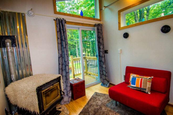 red sofa and wood-burning stove near sliding glass doors