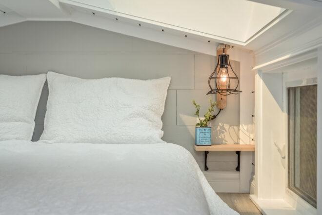 a white bedroom with unique light fixtures