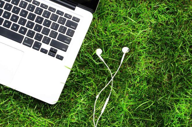 laptop and headphones in grass