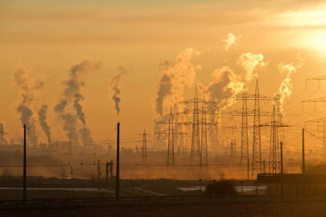 smoke emitting from an industrial plant at sunset