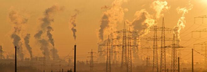 smoke emitting from an industrial plant at sunset