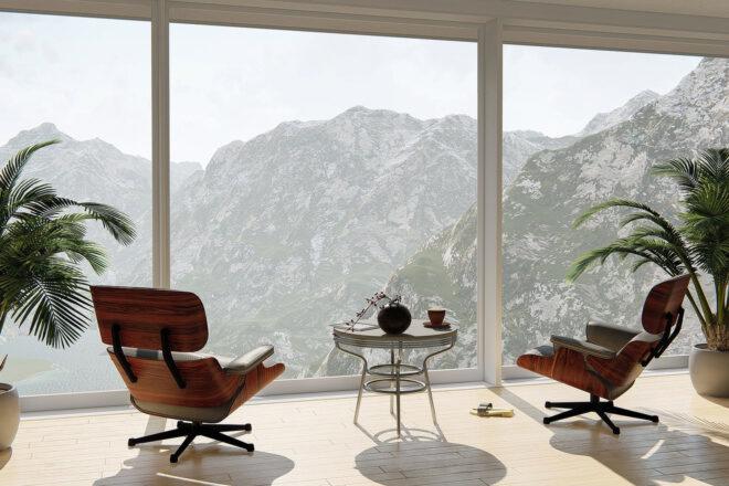 two chairs and two plants facing a glass window with mountainous views
