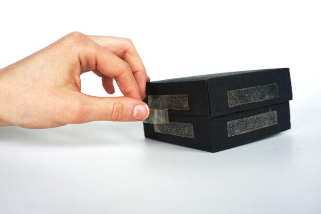 person applying bioplastic tape to a box