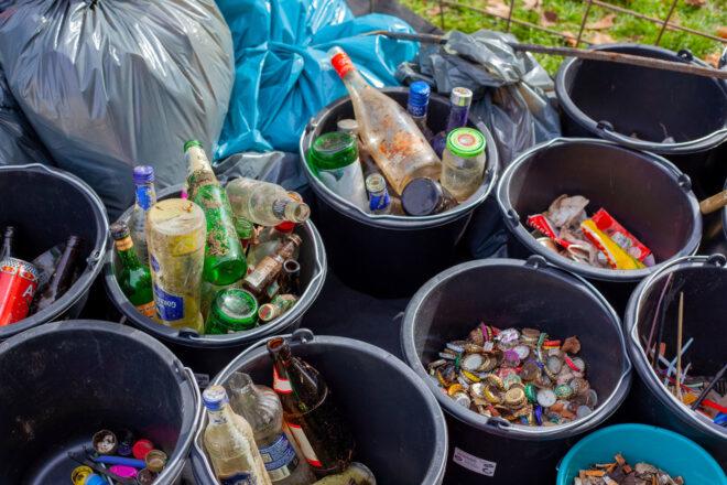 black trash bins filled with bottles and bottle caps