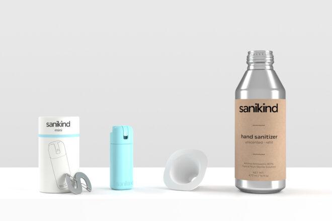 from left to right: a white package with the words "sanikind mini" on it and a silver caribiner in front of it, a blue bottle of sanitizer, white funnel and tall silver bottle of sanitzer refills.