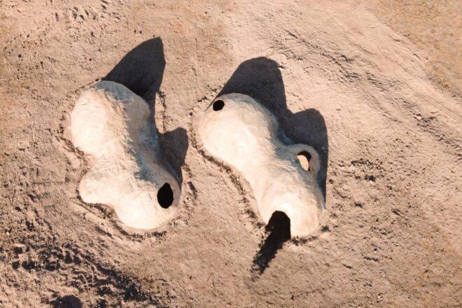 aerial view of two elongated, irregular domes in the desert