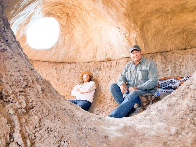 people resting against earth and paper walls of a dome home