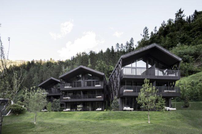 three black buildings with gabled roofs