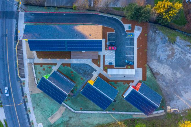 aerial view of gabled roof buildings topped with solar panels