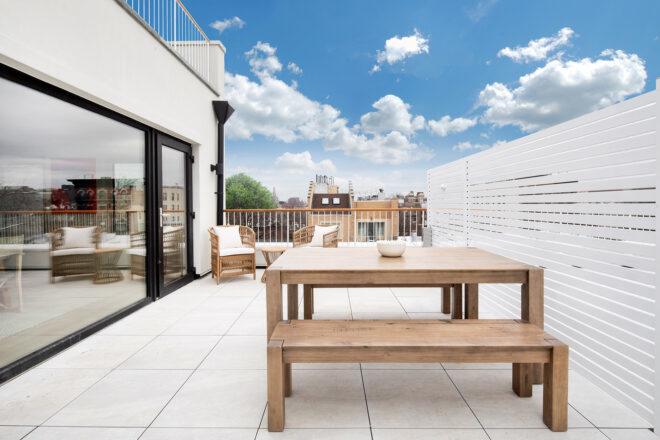 enclosed outdoor patio with wood table and benches