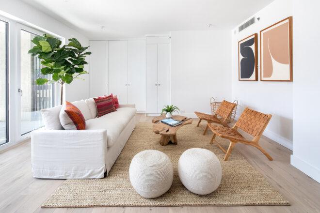 white sofa facing two brown chairs