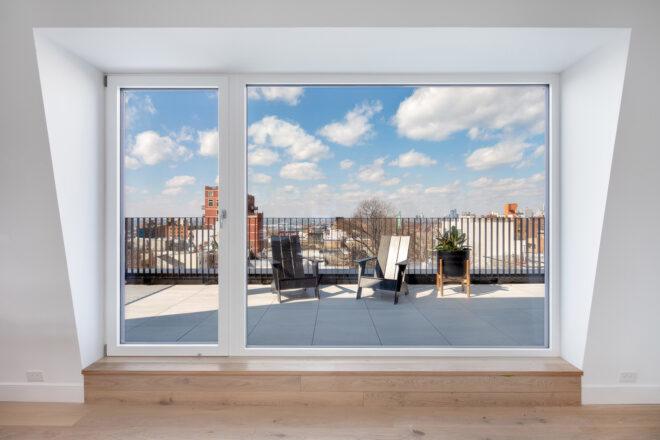large sliding glass door to a balcony with a table and chairs