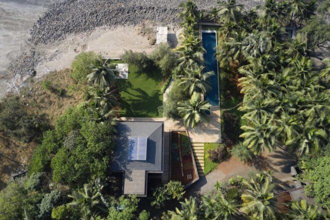 aerial view of coastal home with solar panels on roof