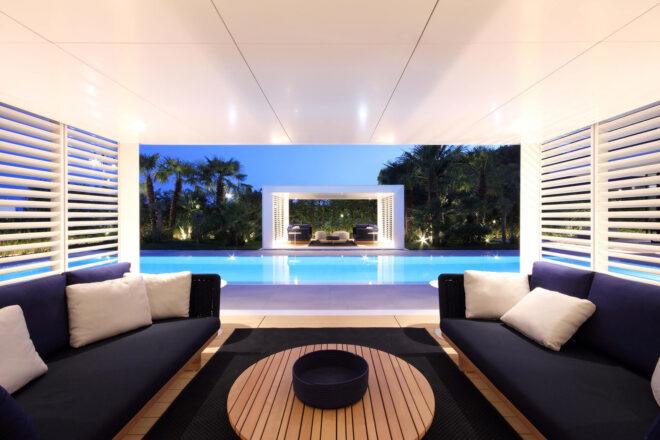 two gray chairs in a cabana beside a pool