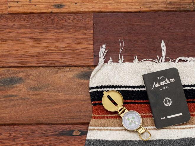 striped blanket, small book and a pocket watch on wood floors
