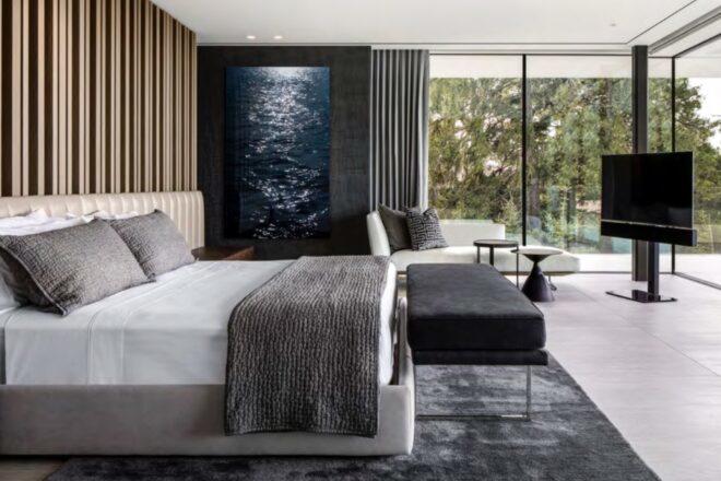 large white bed facing a wall of glass