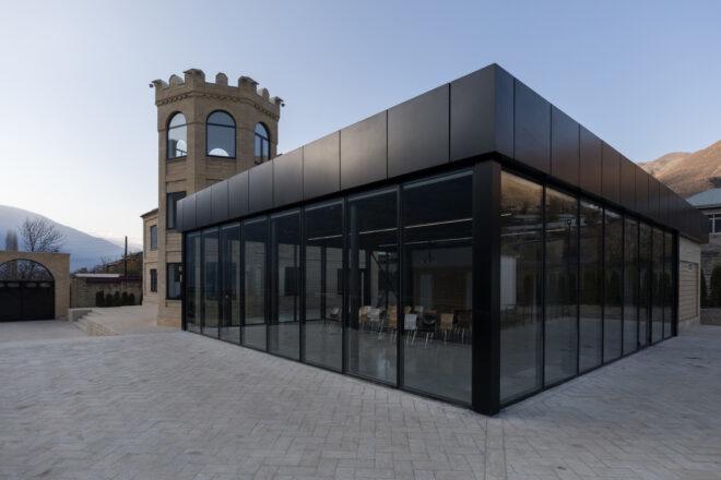 black metal building with full-height glass panels