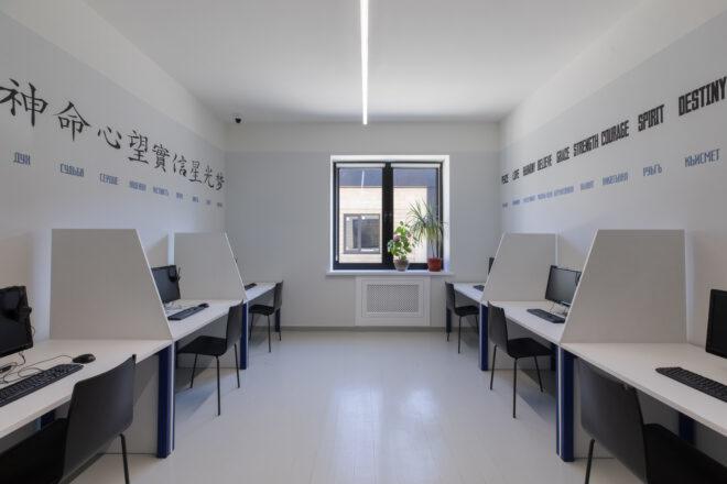 white classroom with computers on desks against each wall