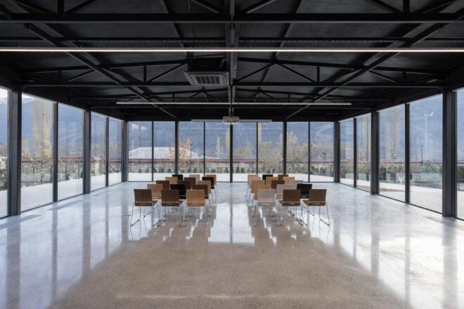 large room with several chairs in the center and walls made of glass