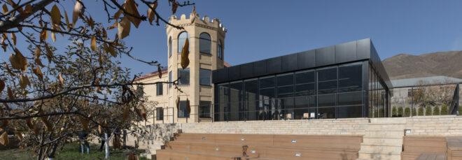 castle-like school building next to black metal and glass building
