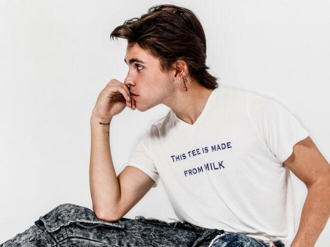 person wearing white T-shirt that reads, "This Tee Is Made From Milk"