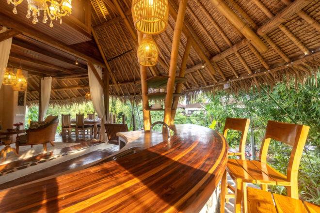curved wood bar under thatched roof