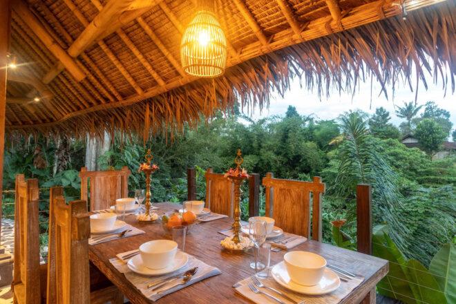 long wood dining table under thatched roof