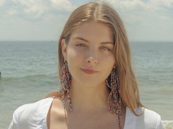 Person wearing multicolored draping earrings