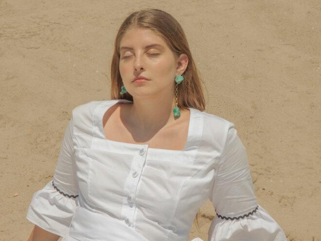 person wearing turquoise stone earrings