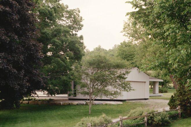 light wood home with gabled roof surrounded by trees