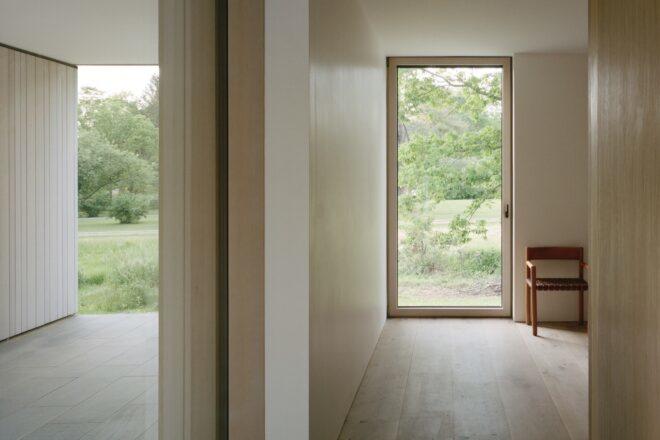 hallway leading to room lined in untreated wood