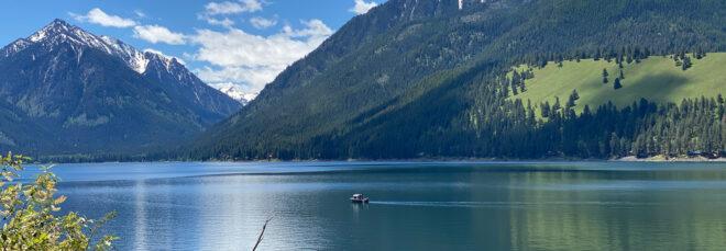 small boat on a river next to mountainous landscape
