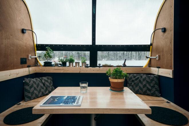 small wood table with plant and bench inside a boat