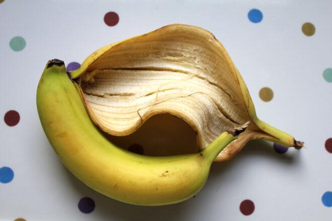 banana peel and unpeeled banana on polka-dot background