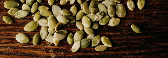 green seeds against a wood table