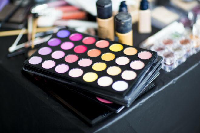 eye shadow palettes and bottles of foundation on a vanity