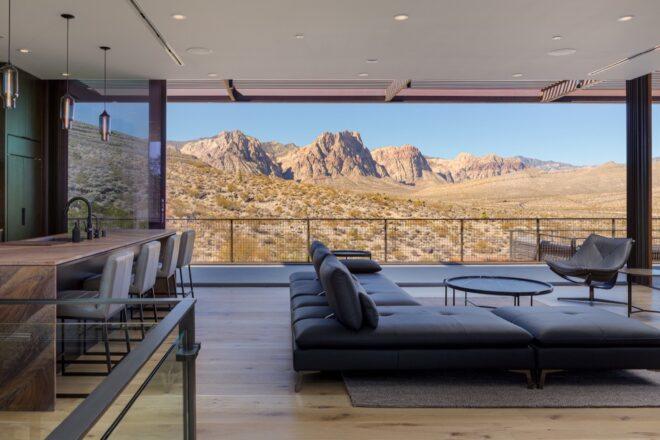 large gray sofa in room with glass wall revealing desert views