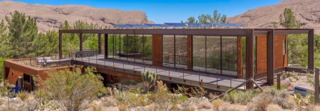 elongated weathered steel home with solar panels on roof