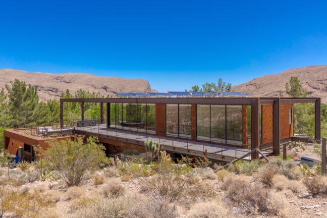 elongated weathered steel home with solar panels on roof