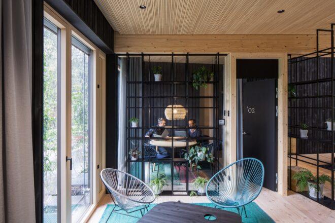 two wire chairs and a table near a glass door