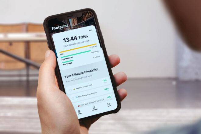 person calculating their carbon footprint with smartphone app