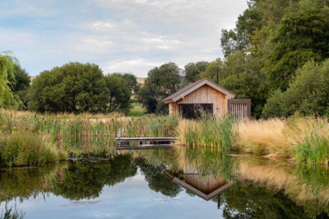 gabled wood cabin facing a lake