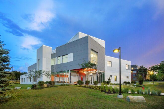 light and dark gray college building on green landscape