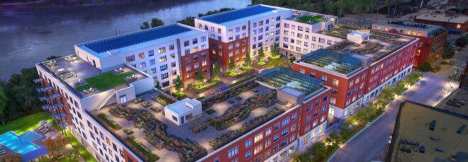 aerial view of large red and white building with green roof